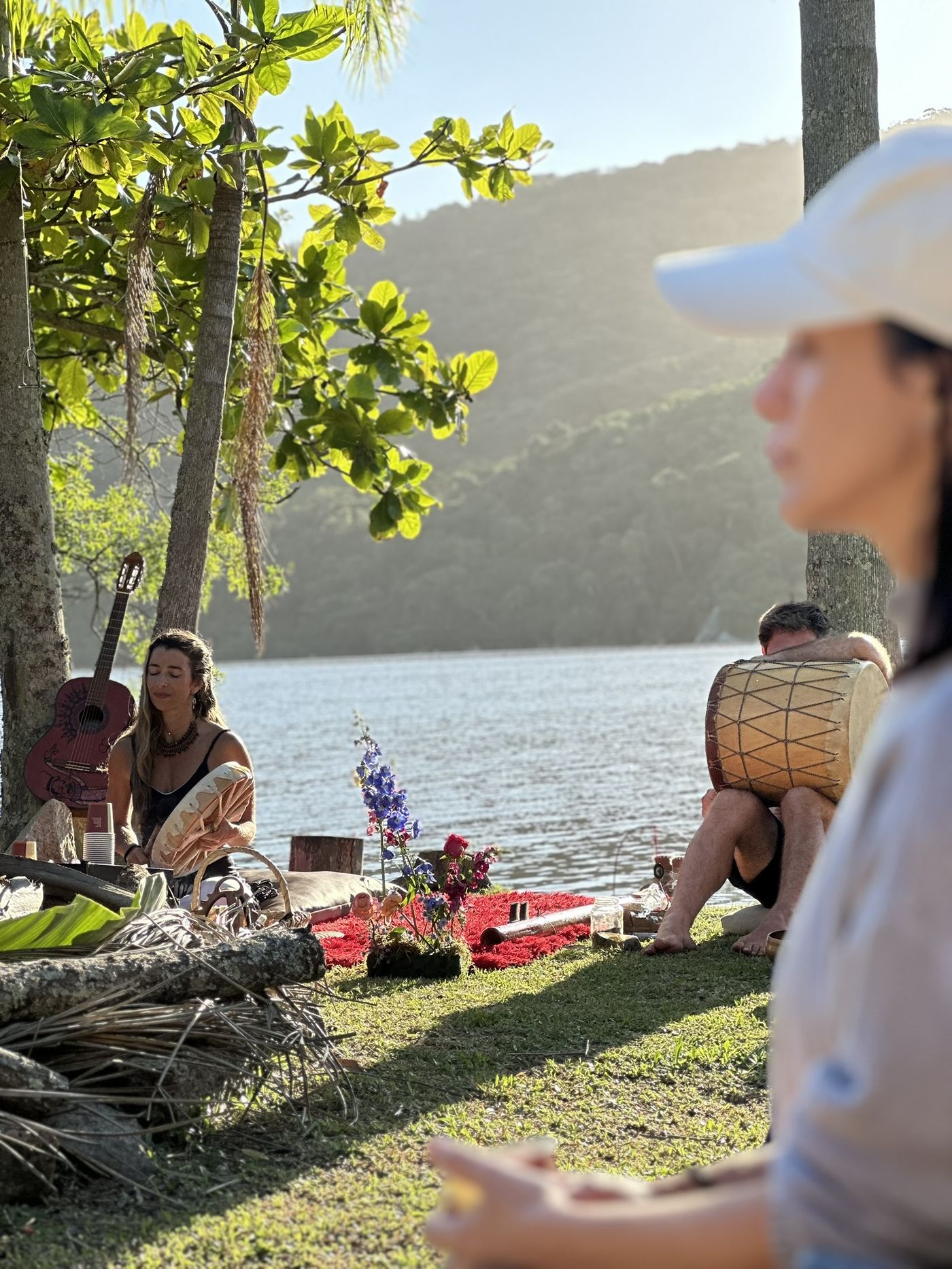 Participantes relaxando na grama à beira da Lagoa